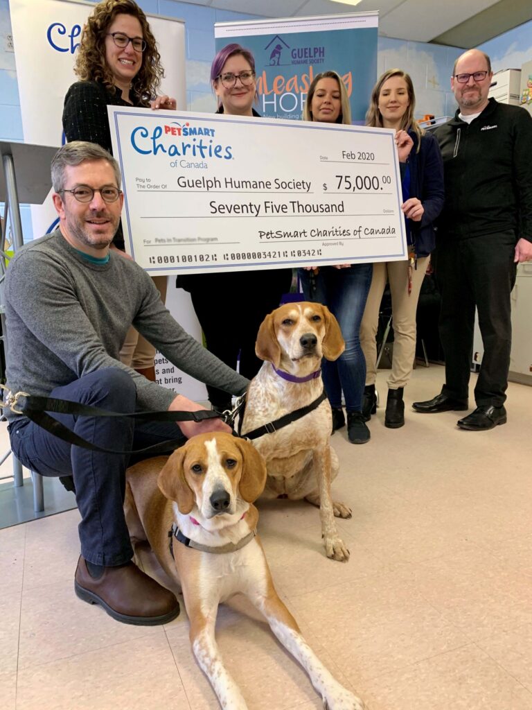 GHS staff and PetSmart Charities of Canada representatives with two hound dogs, holding an oversized $75,000 cheque