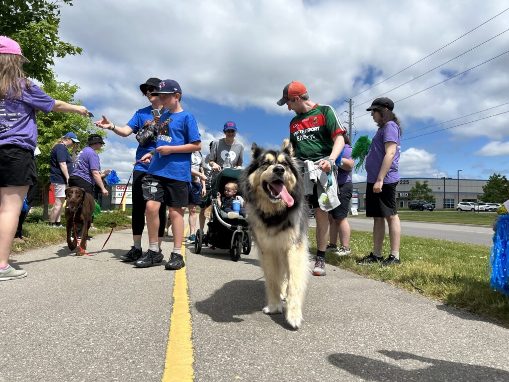 Participants and their dogs gathered on a path at the Happy Trails Walk-a-Thon